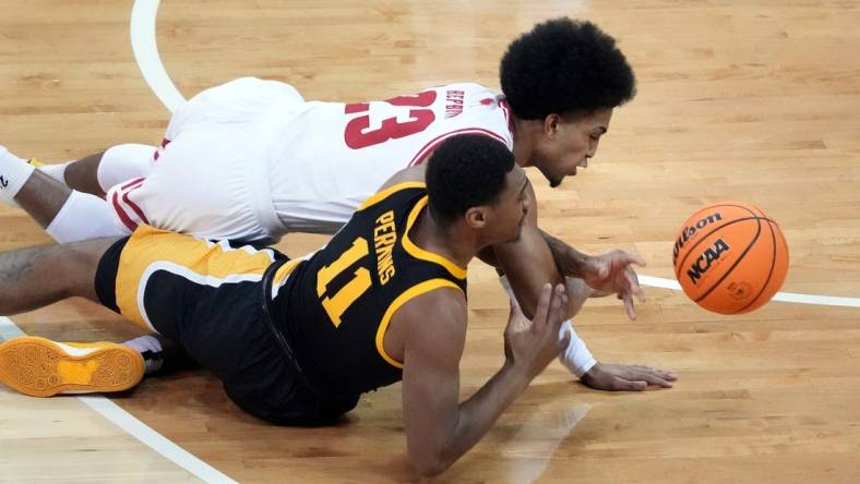 Jan 2, 2024; Madison, Wisconsin, USA;  Wisconsin Badgers guard Chucky Hepburn (23) and Iowa Hawkeyes guard Tony Perkins (11) go after a loose ball during the first half at the Kohl Center. Mandatory Credit: Kayla Wolf-USA TODAY Sports