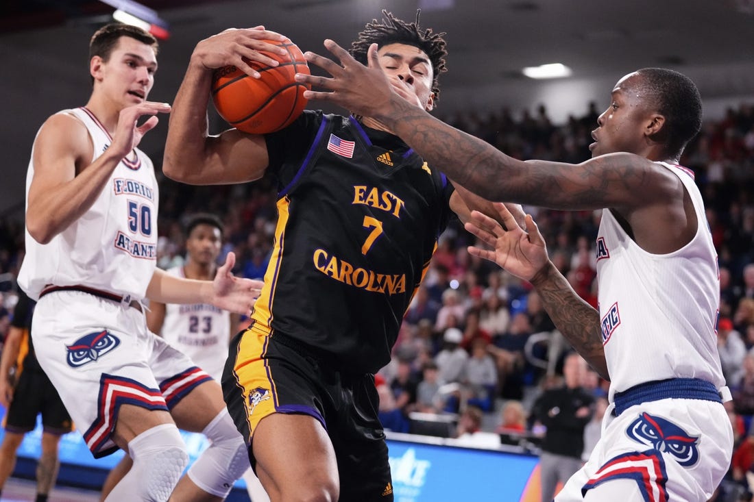 Jan 2, 2024; Boca Raton, Florida, USA; East Carolina Pirates guard Quentin Diboundje (7) dribbles against Florida Atlantic Owls guard Johnell Davis (1) during the first half at Eleanor R. Baldwin Arena. Mandatory Credit: Rich Storry-USA TODAY Sports