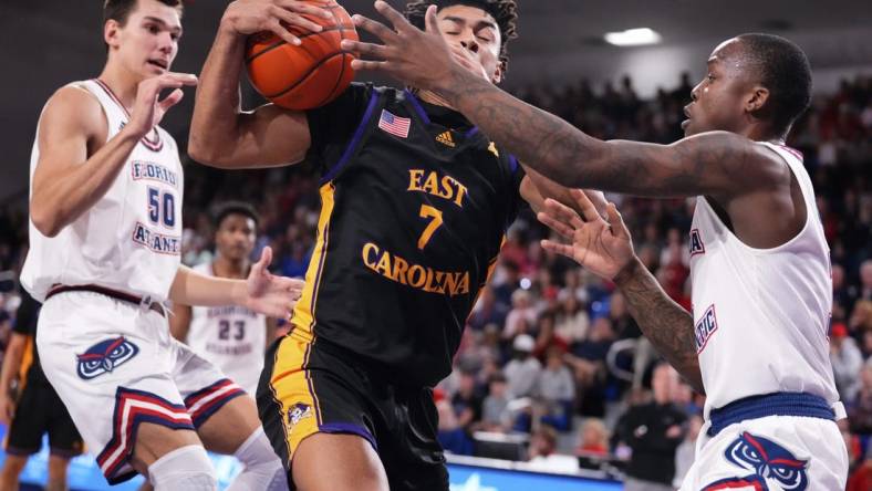 Jan 2, 2024; Boca Raton, Florida, USA; East Carolina Pirates guard Quentin Diboundje (7) dribbles against Florida Atlantic Owls guard Johnell Davis (1) during the first half at Eleanor R. Baldwin Arena. Mandatory Credit: Rich Storry-USA TODAY Sports