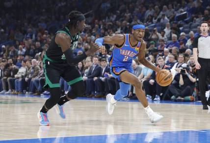 Jan 2, 2024; Oklahoma City, Oklahoma, USA; Oklahoma City Thunder guard Shai Gilgeous-Alexander (2) drives to the basket beside Boston Celtics guard Jrue Holiday (4) during the first quarter at Paycom Center. Mandatory Credit: Alonzo Adams-USA TODAY Sports