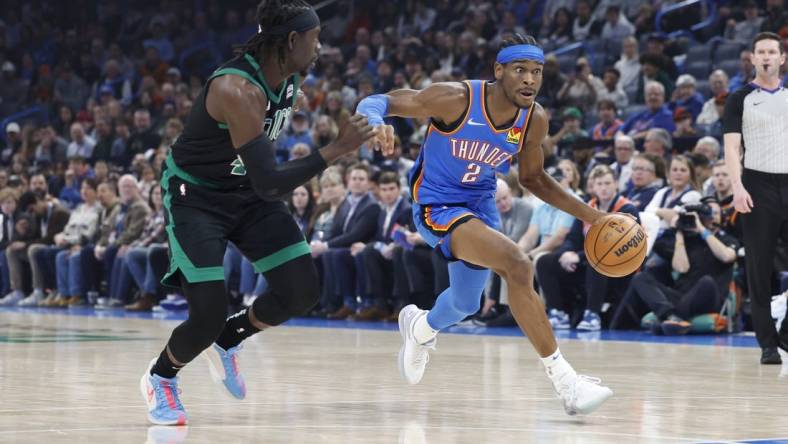 Jan 2, 2024; Oklahoma City, Oklahoma, USA; Oklahoma City Thunder guard Shai Gilgeous-Alexander (2) drives to the basket beside Boston Celtics guard Jrue Holiday (4) during the first quarter at Paycom Center. Mandatory Credit: Alonzo Adams-USA TODAY Sports