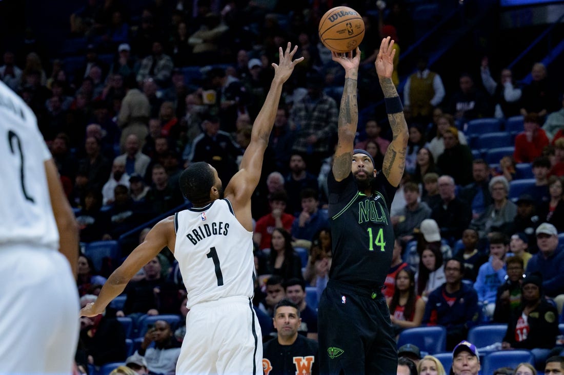 Jan 2, 2024; New Orleans, Louisiana, USA;  New Orleans Pelicans forward Brandon Ingram (14) shoots a three point basket against Brooklyn Nets forward Mikal Bridges (1) at Smoothie King Center. Mandatory Credit: Matthew Hinton-USA TODAY Sports