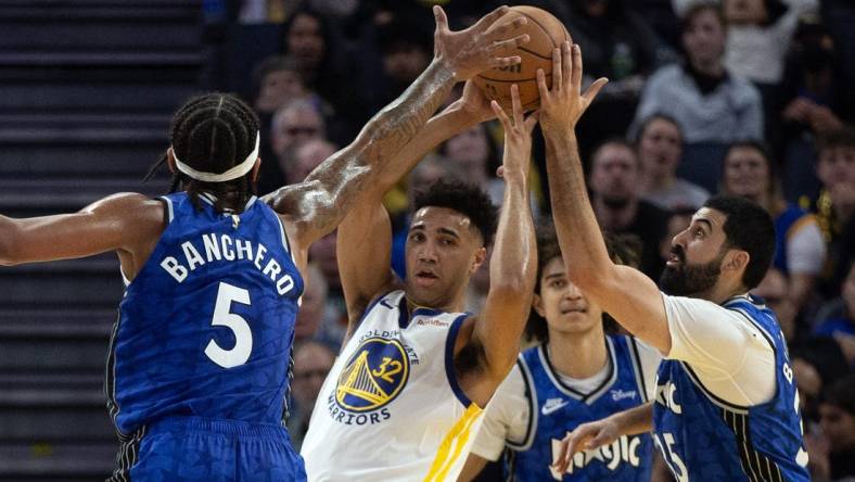 Jan 2, 2024; San Francisco, California, USA; Golden State Warriors forward Trayce Jackson-Davis (32) looks to pass away from defensive pressure from Orlando Magic players during the second quarter at Chase Center. Mandatory Credit: D. Ross Cameron-USA TODAY Sports