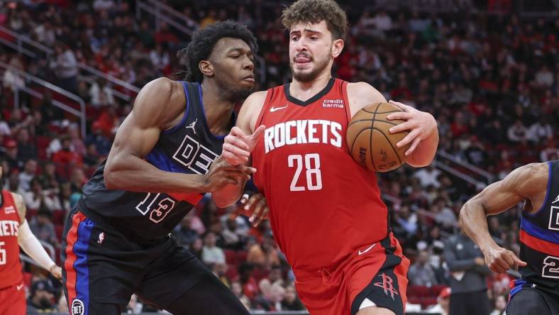 Jan 1, 2024; Houston, Texas, USA; Houston Rockets center Alperen Sengun (28) controls the ball as Detroit Pistons center James Wiseman (13) defends during the game at Toyota Center. Mandatory Credit: Troy Taormina-USA TODAY Sports