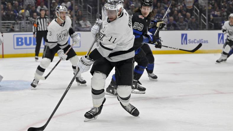 Jan 2, 2024; Los Angeles, California, USA; Los Angeles Kings center Anze Kopitar (11) keeps the puck from Toronto Maple Leafs left wing Tyler Bertuzzi (59) in the first period at Crypto.com Arena. Mandatory Credit: Jayne Kamin-Oncea-USA TODAY Sports