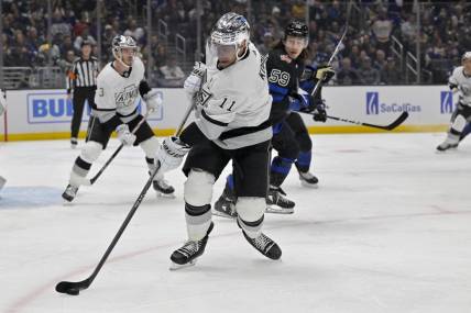 Jan 2, 2024; Los Angeles, California, USA; Los Angeles Kings center Anze Kopitar (11) keeps the puck from Toronto Maple Leafs left wing Tyler Bertuzzi (59) in the first period at Crypto.com Arena. Mandatory Credit: Jayne Kamin-Oncea-USA TODAY Sports