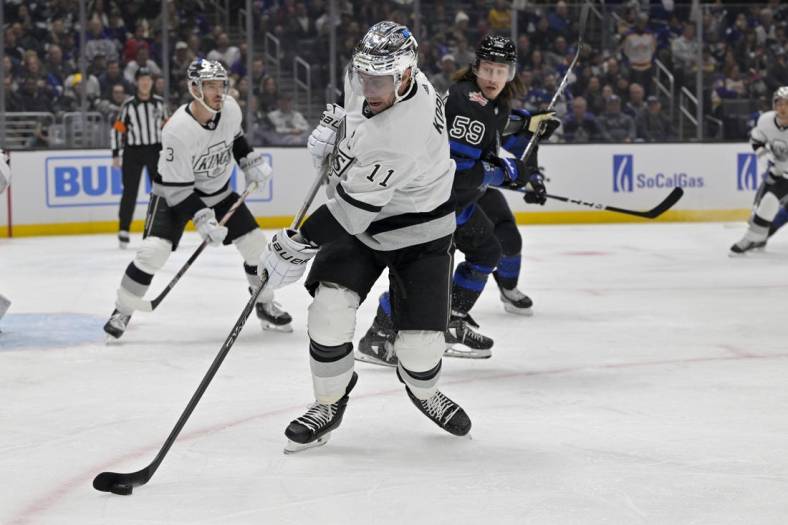 Jan 2, 2024; Los Angeles, California, USA; Los Angeles Kings center Anze Kopitar (11) keeps the puck from Toronto Maple Leafs left wing Tyler Bertuzzi (59) in the first period at Crypto.com Arena. Mandatory Credit: Jayne Kamin-Oncea-USA TODAY Sports