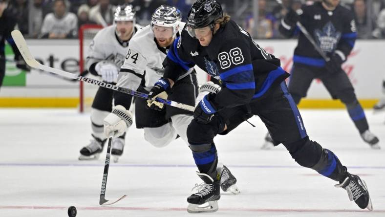 Jan 2, 2024; Los Angeles, California, USA; Toronto Maple Leafs right wing William Nylander (88) skates the puck past Los Angeles Kings defenseman Vladislav Gavrikov (84) in the first period at Crypto.com Arena. Mandatory Credit: Jayne Kamin-Oncea-USA TODAY Sports