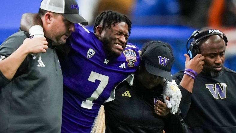 Washington running back Dillon Johnson is helped off the field after an injury during the Huskies' final possession of a 37-31 win against Texas in the Sugar Bowl. Wednesday UW coach Kalen DeBoer said Johnson expects to play in the national championship against Michigan.