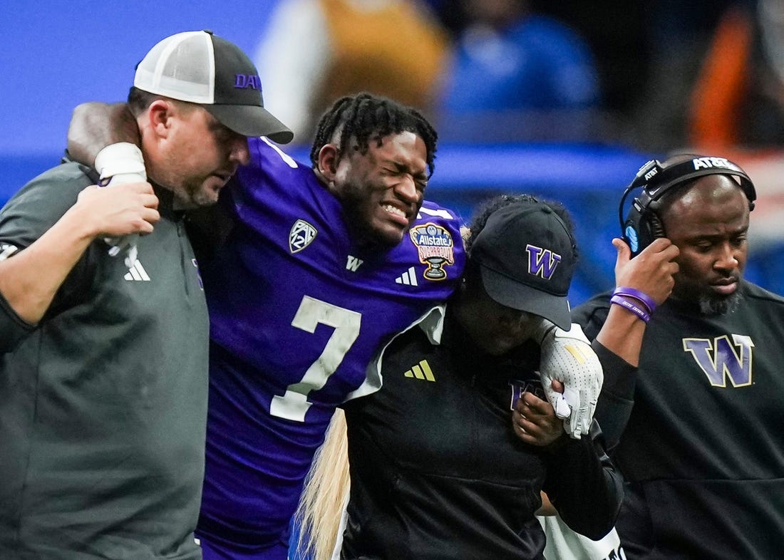 Washington running back Dillon Johnson is helped off the field after an injury during the Huskies' final possession of a 37-31 win against Texas in the Sugar Bowl. Wednesday UW coach Kalen DeBoer said Johnson expects to play in the national championship against Michigan.