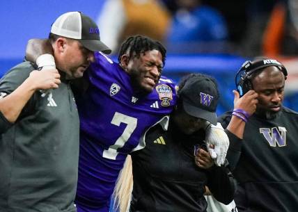 Washington running back Dillon Johnson is helped off the field after an injury during the Huskies' final possession of a 37-31 win against Texas in the Sugar Bowl. Wednesday UW coach Kalen DeBoer said Johnson expects to play in the national championship against Michigan.