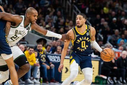 Jan 3, 2024; Indianapolis, Indiana, USA; Indiana Pacers guard Tyrese Haliburton (0) dribbles the ball while Milwaukee Bucks forward Khris Middleton (22) defends in the second half at Gainbridge Fieldhouse. Mandatory Credit: Trevor Ruszkowski-USA TODAY Sports