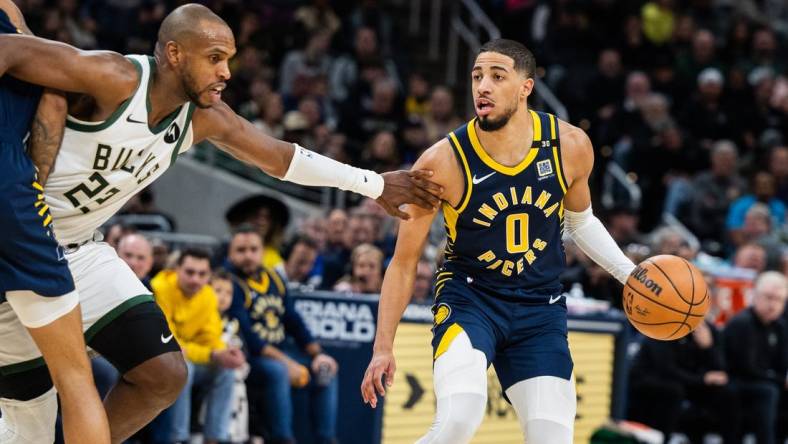 Jan 3, 2024; Indianapolis, Indiana, USA; Indiana Pacers guard Tyrese Haliburton (0) dribbles the ball while Milwaukee Bucks forward Khris Middleton (22) defends in the second half at Gainbridge Fieldhouse. Mandatory Credit: Trevor Ruszkowski-USA TODAY Sports