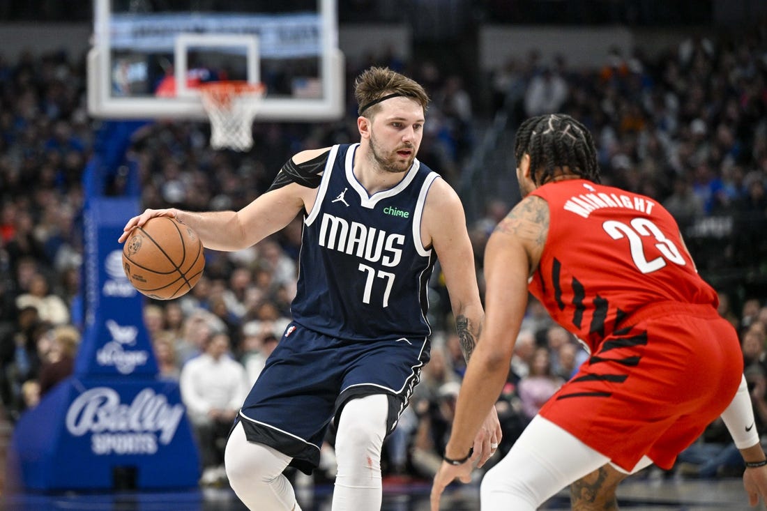 Jan 3, 2024; Dallas, Texas, USA; Dallas Mavericks guard Luka Doncic (77) looks to move the ball past Portland Trail Blazers forward Ish Wainright (23) during the second half at the American Airlines Center. Mandatory Credit: Jerome Miron-USA TODAY Sports