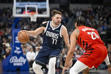 Jan 3, 2024; Dallas, Texas, USA; Dallas Mavericks guard Luka Doncic (77) looks to move the ball past Portland Trail Blazers forward Ish Wainright (23) during the second half at the American Airlines Center. Mandatory Credit: Jerome Miron-USA TODAY Sports