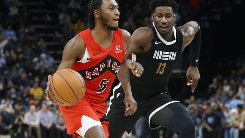 Jan 3, 2024; Memphis, Tennessee, USA; Toronto Raptors guard Immanuel Quickley (5) drives to the basket as Memphis Grizzlies forward-center Jaren Jackson Jr. (13) defends during the second half at FedExForum. Mandatory Credit: Petre Thomas-USA TODAY Sports