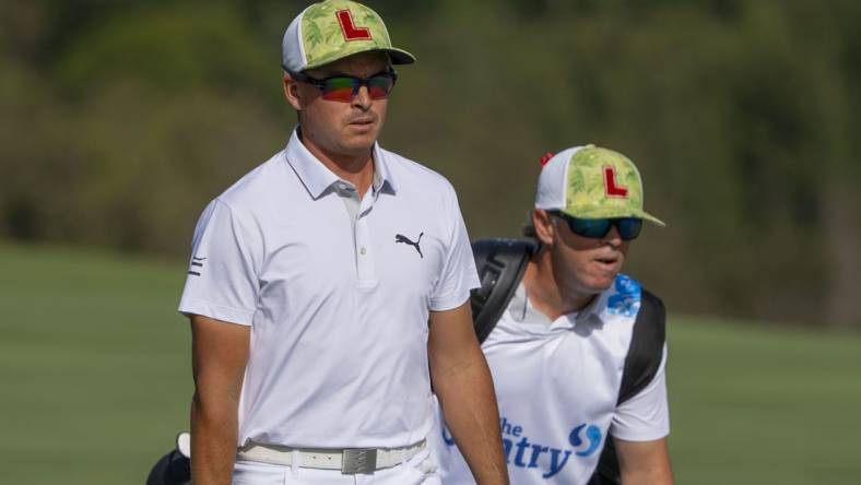 January 4, 2024; Maui, Hawaii, USA; Rickie Fowler (left) and caddie caddie Ricky Romano (right) walk on the fourth hole during the first round of The Sentry Tournament of Champions golf tournament at Kapalua Golf - The Plantation Course. Mandatory Credit: Kyle Terada-USA TODAY Sports