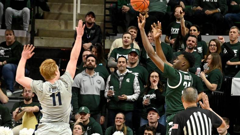 Jan 4, 2024; East Lansing, Michigan, USA; Michigan State Spartans forward Xavier Booker (34) shoots past Penn State Nittany Lions forward Leo O'Boyle (11) during the first half at Jack Breslin Student Events Center. Mandatory Credit: Dale Young-USA TODAY Sports