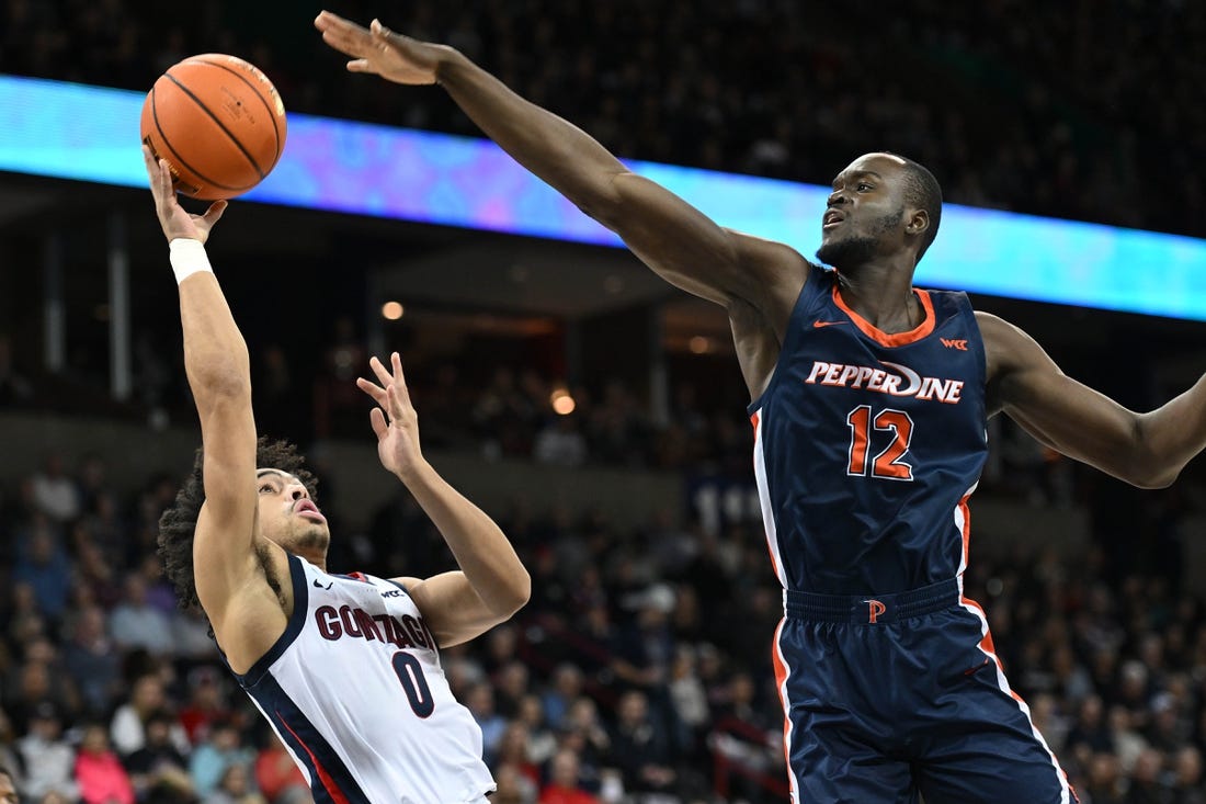 Jan 4, 2024; Spokane, Washington, USA; Gonzaga Bulldogs guard Ryan Nembhard (0) shoots the ball against Pepperdine Waves forward Boubacar Coulibaly (12) in the first half at Spokane Arena. Mandatory Credit: James Snook-USA TODAY Sports