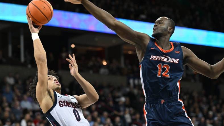 Jan 4, 2024; Spokane, Washington, USA; Gonzaga Bulldogs guard Ryan Nembhard (0) shoots the ball against Pepperdine Waves forward Boubacar Coulibaly (12) in the first half at Spokane Arena. Mandatory Credit: James Snook-USA TODAY Sports