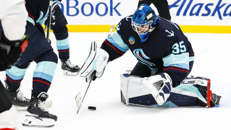 Jan 4, 2024; Seattle, Washington, USA; Seattle Kraken goaltender Joey Daccord (35) collects the puck during the first period against the Ottawa Senators at Climate Pledge Arena. Mandatory Credit: Joe Nicholson-USA TODAY Sports