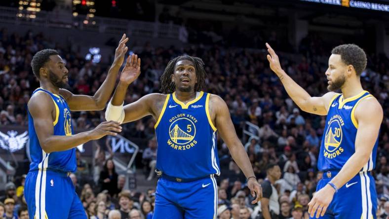 Jan 4, 2024; San Francisco, California, USA; Golden State Warriors forward Andrew Wiggins (22) and guard Kevon Looney (5) and guard Stephen Curry (30) react after drawing a foul against the Denver Nuggets during the first half at Chase Center. Mandatory Credit: John Hefti-USA TODAY Sports