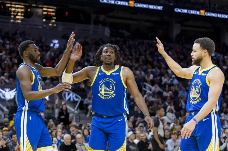 Jan 4, 2024; San Francisco, California, USA; Golden State Warriors forward Andrew Wiggins (22) and guard Kevon Looney (5) and guard Stephen Curry (30) react after drawing a foul against the Denver Nuggets during the first half at Chase Center. Mandatory Credit: John Hefti-USA TODAY Sports