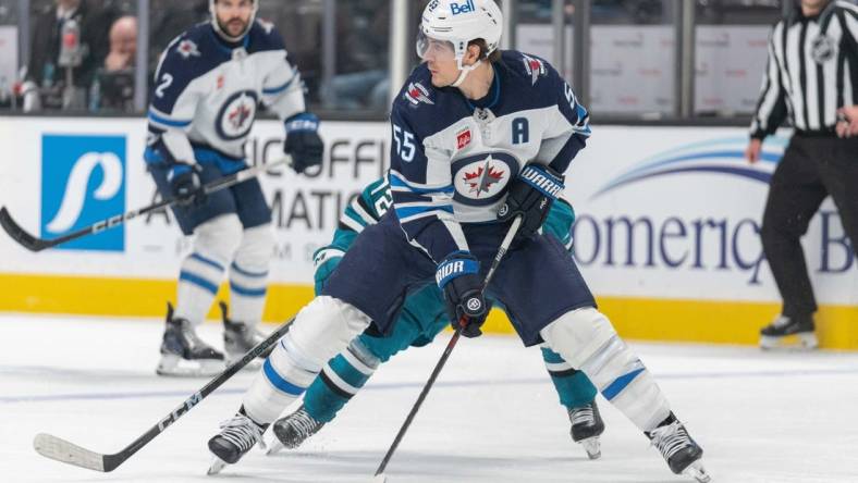 Jan 4, 2024; San Jose, California, USA;s Winnipeg Jets center Mark Scheifele (55) controls the puck during the second period against San Jose Sharks left wing William Eklund (72) at SAP Center at San Jose. Mandatory Credit: Stan Szeto-USA TODAY Sports