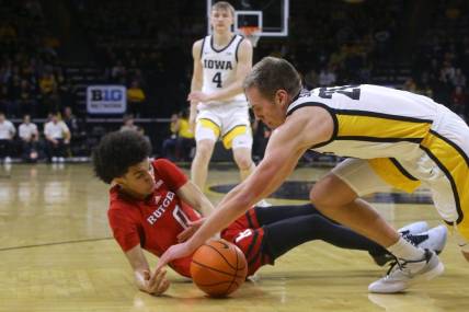 Iowa's Payton Sandfort (20) dives for a loose ball with Rutgers' Derek Simpson (0) Saturday, Jan. 6, 2024 at Carver-Hawkeye Arena in Iowa City, Iowa.