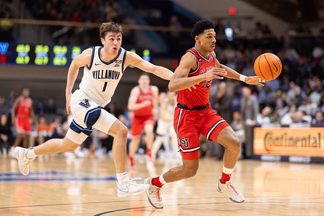 Jan 6, 2024; Villanova, Pennsylvania, USA; St. John's Red Storm guard RJ Luis Jr. (12) picks up the loose ball past Villanova Wildcats guard Brendan Hausen (1) during the second half at William B. Finneran Pavilion. Mandatory Credit: Bill Streicher-USA TODAY Sports