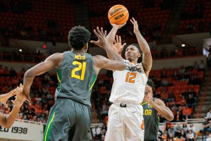 Jan 6, 2024; Stillwater, Oklahoma, USA;  Oklahoma State Cowboys guard Javon Small (12) puts up a shot over Baylor Bears center Yves Missi (21) during the first half at Gallagher-Iba Arena. Mandatory Credit: William Purnell-USA TODAY Sports