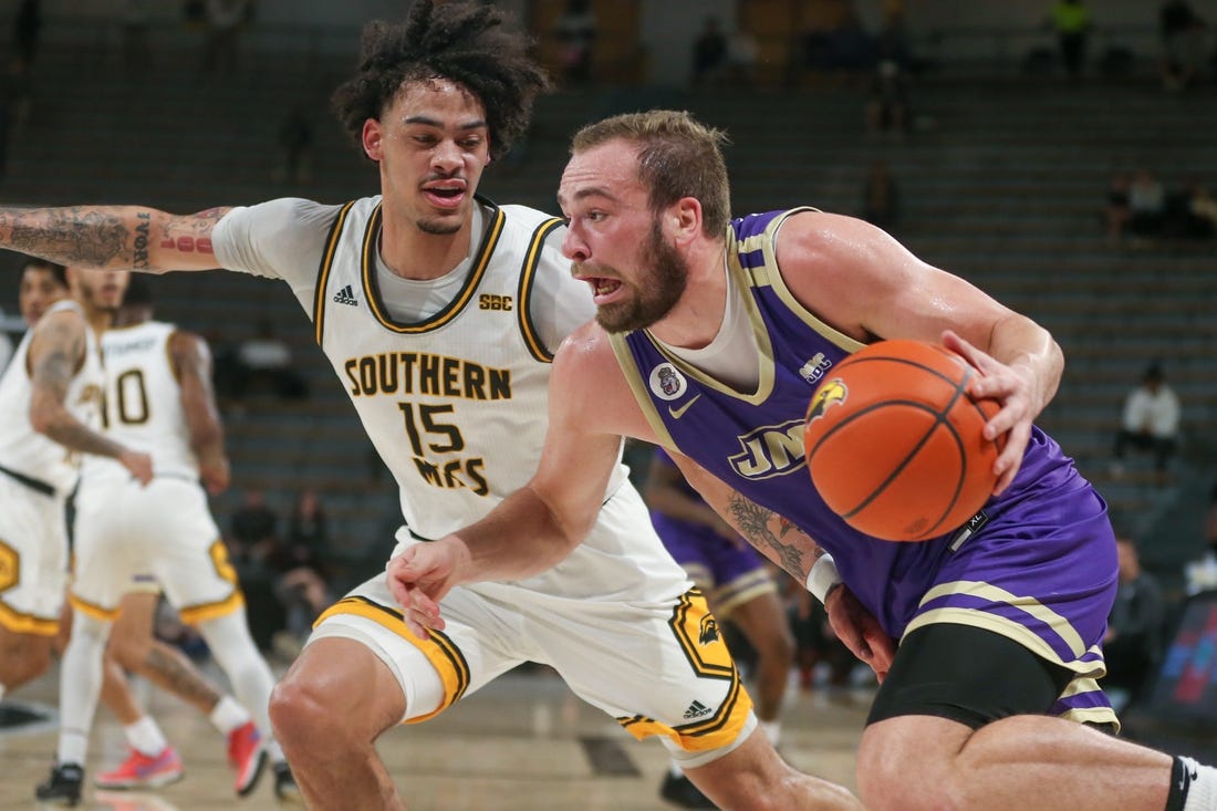 Jan 6, 2024; Hattiesburg, Mississippi, USA; James Madison Dukes guard Noah Freidel (1) drives on Southern Miss Golden Eagles guard Donovan Ivory (15) during the first half at Reed Green Coliseum. Mandatory Credit: Chuck Cook-USA TODAY Sports