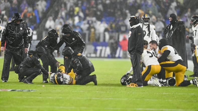 Jan 6, 2024; Baltimore, Maryland, USA;  Pittsburgh Steelers medical staff tend to inebacker T.J. Watt (left) as teammates take a knee during the third  quarter against the Baltimore Ravens at M&T Bank Stadium. Mandatory Credit: Tommy Gilligan-USA TODAY Sports