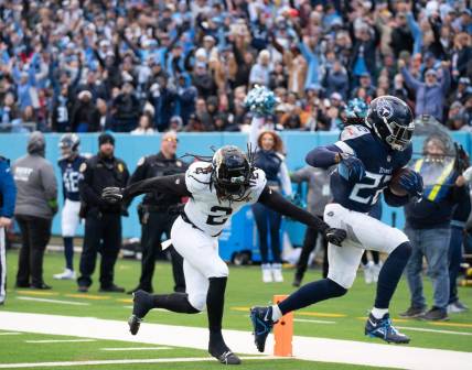 Tennessee Titans running back Derrick Henry (22) runs past Jacksonville Jaguars safety Rayshawn Jenkins (2) for a touchdown in the second quarter of their game at Nissan Stadium in Nashville, Tenn., Sunday, Jan. 7, 2024.