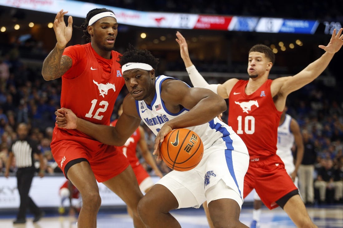 Jan 7, 2024; Memphis, Tennessee, USA; Memphis Tigers forward Malcolm Dandridge (23) dribbles as Southern Methodist Mustangs forward Tyreek Smith (12) and forward Samuell Williamson (10) defend during the first half at FedExForum. Mandatory Credit: Petre Thomas-USA TODAY Sports