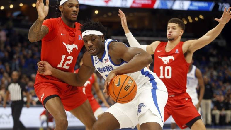 Jan 7, 2024; Memphis, Tennessee, USA; Memphis Tigers forward Malcolm Dandridge (23) dribbles as Southern Methodist Mustangs forward Tyreek Smith (12) and forward Samuell Williamson (10) defend during the first half at FedExForum. Mandatory Credit: Petre Thomas-USA TODAY Sports