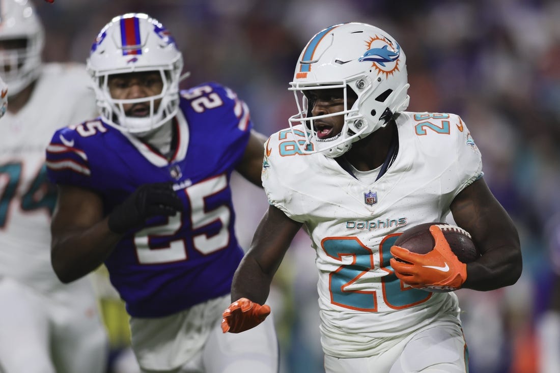 Jan 7, 2024; Miami Gardens, Florida, USA; Miami Dolphins running back De'Von Achane (28) runs with the football against the Buffalo Bills during the first quarter at Hard Rock Stadium. Mandatory Credit: Sam Navarro-USA TODAY Sports