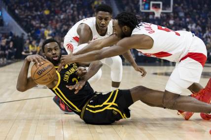 Jan 7, 2024; San Francisco, California, USA;  Golden State Warriors forward Andrew Wiggins (22) and Toronto Raptors guard Immanuel Quickley (5) and forward RJ Barrett (9) battle for possession during the first half at Chase Center. Mandatory Credit: John Hefti-USA TODAY Sports