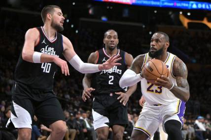 Jan 7, 2024; Los Angeles, California, USA; Los Angeles Lakers forward LeBron James (23) drives past Los Angeles Clippers center Ivica Zubac (40) and forward Kawhi Leonard (2) in the first half at Crypto.com Arena. Mandatory Credit: Jayne Kamin-Oncea-USA TODAY Sports