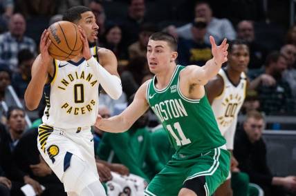 Jan 8, 2024; Indianapolis, Indiana, USA; Indiana Pacers guard Tyrese Haliburton (0) looks to pass the ball while Boston Celtics guard Payton Pritchard (11) defends in the first half at Gainbridge Fieldhouse. Mandatory Credit: Trevor Ruszkowski-USA TODAY Sports