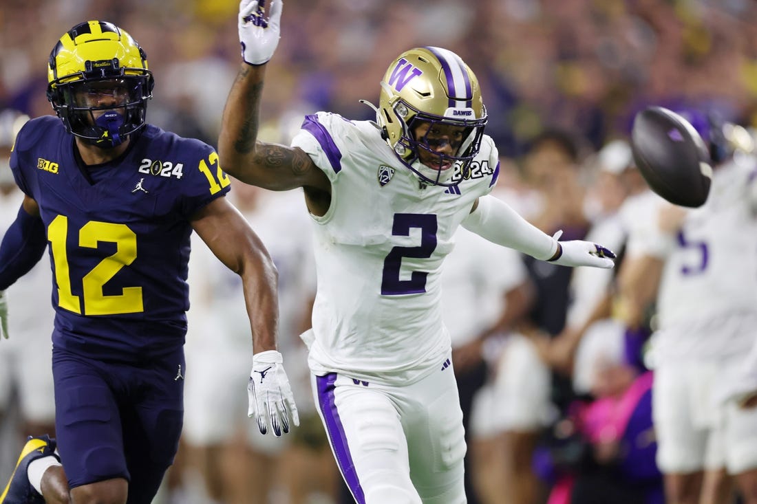 Jan 8, 2024; Houston, TX, USA; Michigan Wolverines defensive back Josh Wallace (12) and Washington Huskies wide receiver Ja'Lynn Polk (2) are unable to catch a pass during the third quarter in the 2024 College Football Playoff national championship game at NRG Stadium. Mandatory Credit: Thomas Shea-USA TODAY Sports