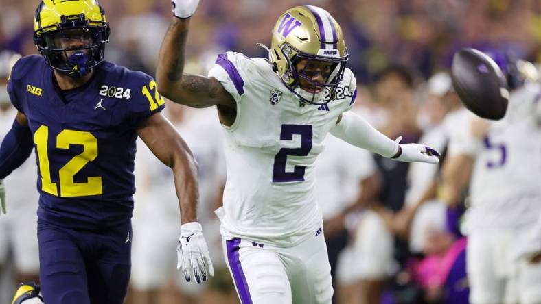 Jan 8, 2024; Houston, TX, USA; Michigan Wolverines defensive back Josh Wallace (12) and Washington Huskies wide receiver Ja'Lynn Polk (2) are unable to catch a pass during the third quarter in the 2024 College Football Playoff national championship game at NRG Stadium. Mandatory Credit: Thomas Shea-USA TODAY Sports