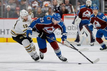 Jan 8, 2024; Denver, Colorado, USA; Colorado Avalanche right wing Logan O'Connor (25) and Boston Bruins center Charlie Coyle (13) battle for the puck in the second period at Ball Arena. Mandatory Credit: Isaiah J. Downing-USA TODAY Sports