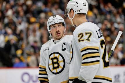 Jan 8, 2024; Denver, Colorado, USA; Boston Bruins left wing Brad Marchand (63) and defenseman Hampus Lindholm (27) in the second period against the Colorado Avalanche at Ball Arena. Mandatory Credit: Isaiah J. Downing-USA TODAY Sports