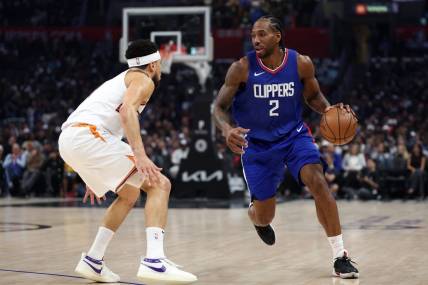 Jan 8, 2024; Los Angeles, California, USA;  Los Angeles Clippers forward Kawhi Leonard (2) dribbles the ball against Phoenix Suns guard Devin Booker (1) during the first quarter at Crypto.com Arena. Mandatory Credit: Kiyoshi Mio-USA TODAY Sports