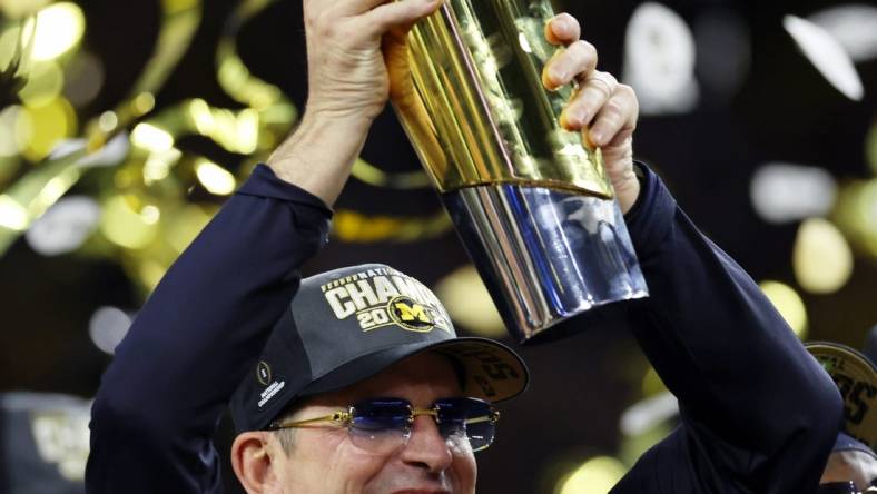 Jan 8, 2024; Houston, TX, USA; Michigan Wolverines head coach Jim Harbaugh holds the National Championship Trophy as he celebrates after winning 2024 College Football Playoff national championship game against the Washington Huskies at NRG Stadium. Mandatory Credit: Thomas Shea-USA TODAY Sports