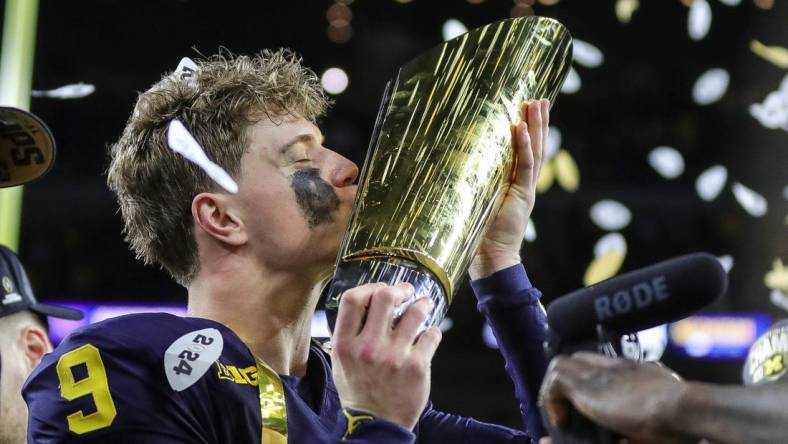 Michigan quarterback J.J. McCarthy kisses the championship trophy to celebrate the Wolverines' 34-13 win over Washington in the national championship game at NRG Stadium in Houston on Monday, Jan. 8, 2024.