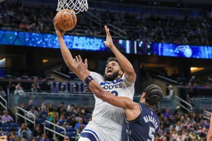 Jan 9, 2024; Orlando, Florida, USA; Minnesota Timberwolves center Karl-Anthony Towns (32) goes to the basket against Orlando Magic forward Paolo Banchero (5) during the second quarter at KIA Center. Mandatory Credit: Mike Watters-USA TODAY Sports