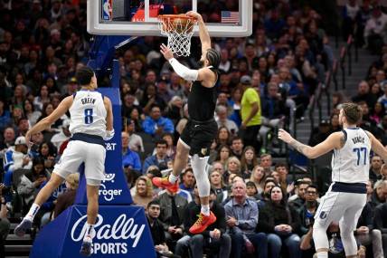 Jan 9, 2024; Dallas, Texas, USA; Memphis Grizzlies forward David Roddy (21) dunks the ball past Dallas Mavericks guard Josh Green (8) and guard Luka Doncic (77) during the second quarter at the American Airlines Center. Mandatory Credit: Jerome Miron-USA TODAY Sports