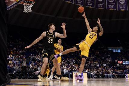 Jan 9, 2024; Baton Rouge, Louisiana, USA; LSU Tigers forward Jalen Reed (13) shoots a jump shot against Vanderbilt Commodores forward Carter Lang (35) during the first half at Pete Maravich Assembly Center. Mandatory Credit: Stephen Lew-USA TODAY Sports